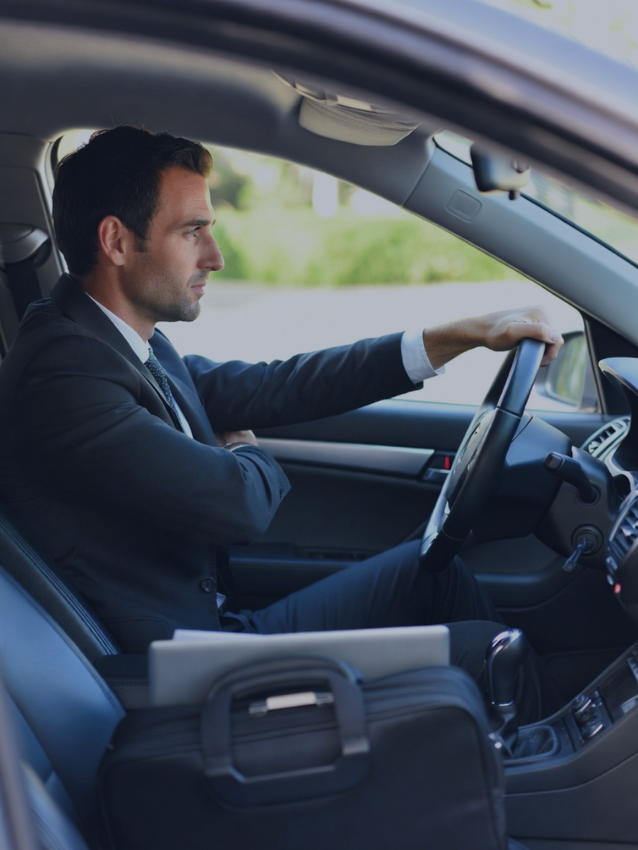 Autónomo conduciendo su vehículo hacia una visita comercial para justificar los gastos de desplazamiento y kilometraje ante Hacienda.